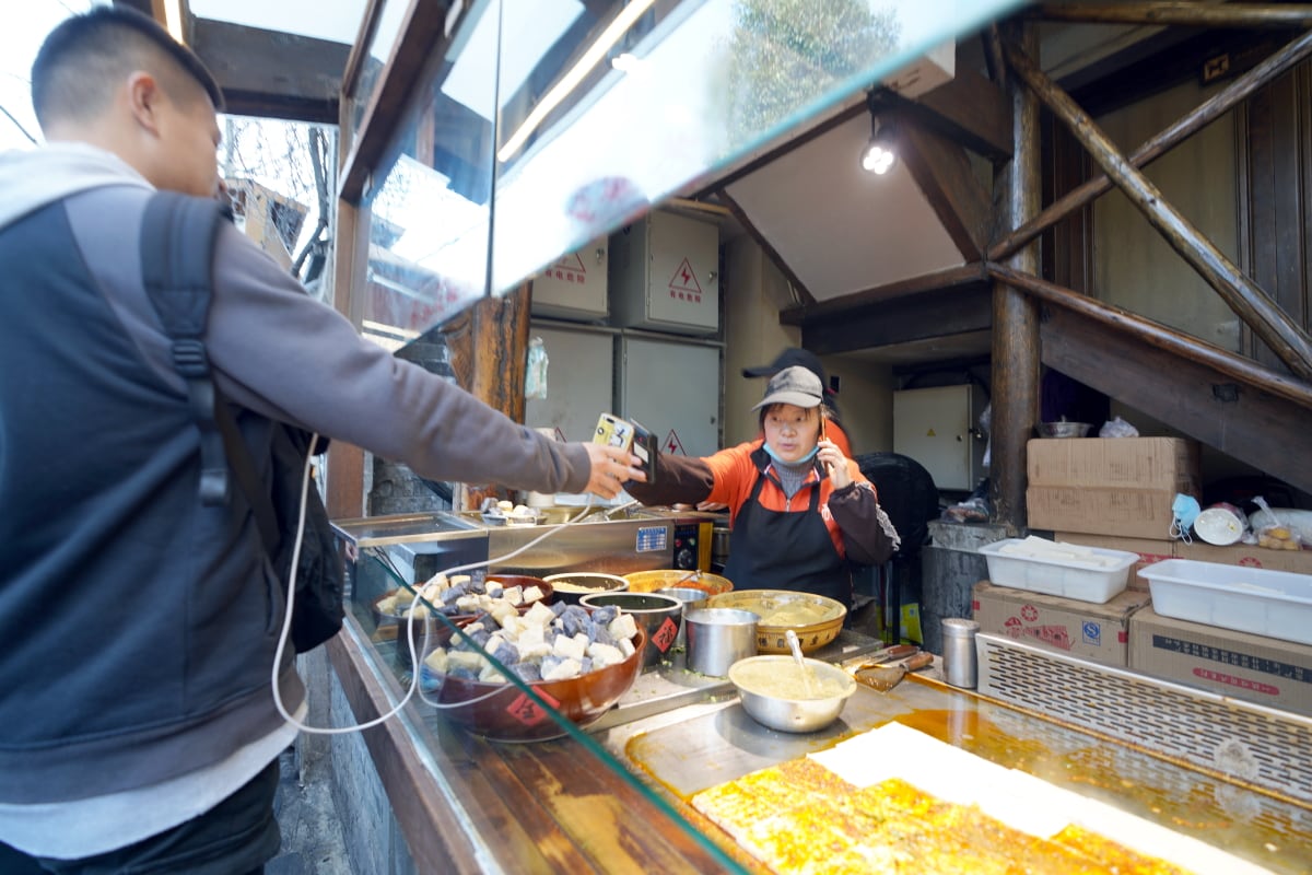 Mobile payment in Asia on the rise: Street food paid with smartphone (Source: B.Zhou/Shutterstock.com)